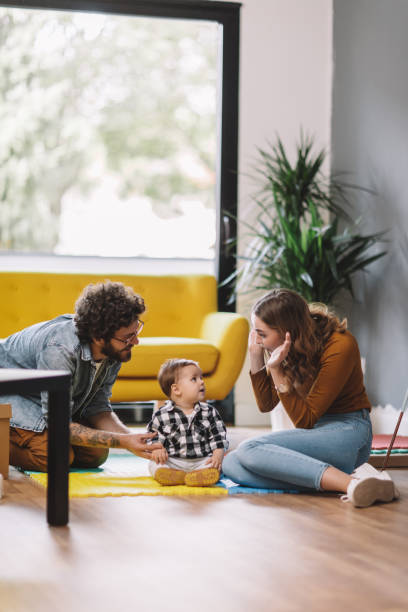 Cheerful parents playing with son at new home