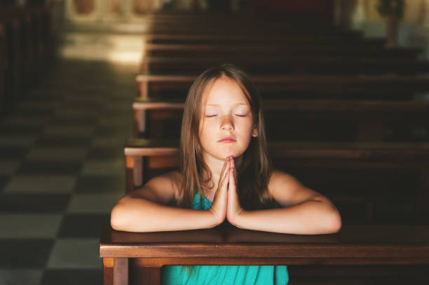 enfant priant dans l’église, le concept de religion - praying joy indoors lifestyles photos et images de collection