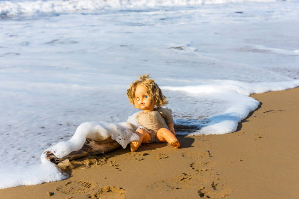 istock Cast Away Broken Doll Washed up on a Beach 1098249718