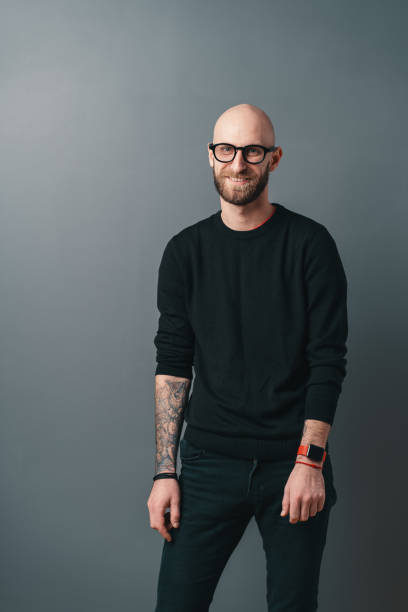 istock Young smiling man with beard and glasses on gray studio background 1098257040