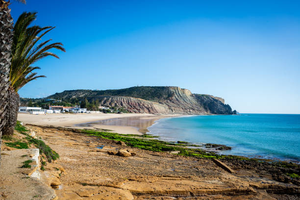 Praia da Luz Great lonely Beach Praia da Luz with the Dragon Stone in the distance lagos portugal stock pictures, royalty-free photos & images