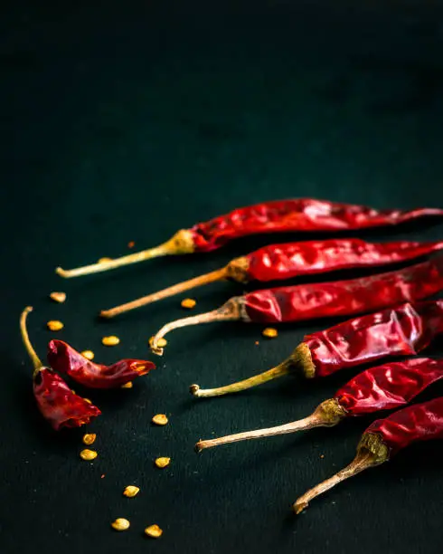 Hot and Dry Red Chili Peppers on Dark Background - Popular Ingredient for Asian Cuisine