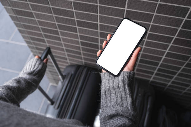 istock Top view mockup image of a woman holding black mobile phone with blank desktop screen while while holding a baggage 1098266668