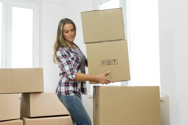 istock Woman carrying moving boxes 1098268244