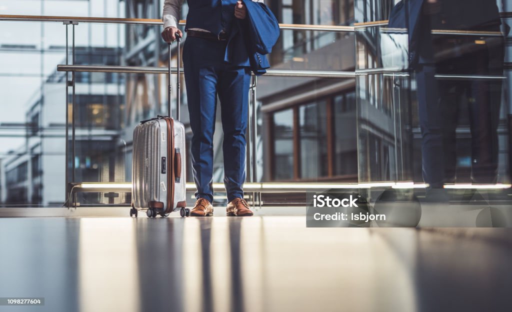Close up of unknown man going to vacation. Close up of businessman waiting for transport. Airport Stock Photo
