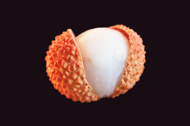 Fresh lychee isolated on black background, macro. Tropical peeled lychee fruit. Litchi chinensis, pinyin, soapberry family, Sapindaceae.