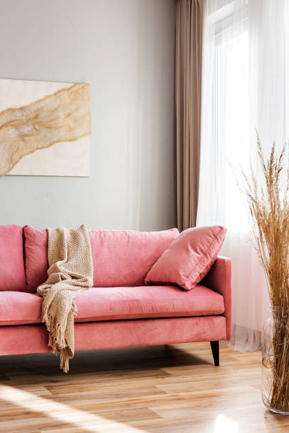 istock Beige blanket on pink couch in bright living room interior 1098280120