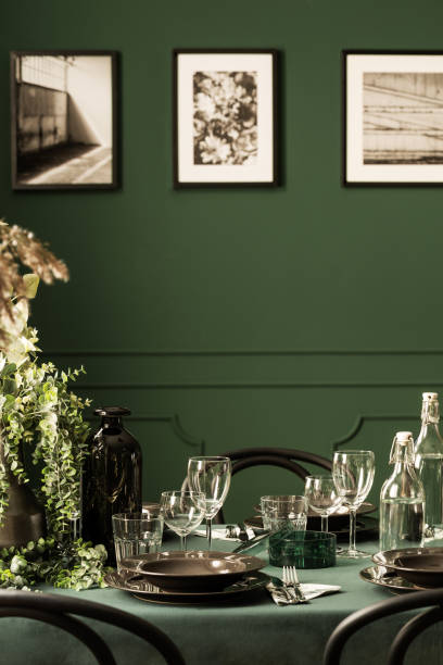 istock Classy dining room table with black plates, wine glasses and green plants 1098283916