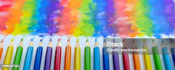 Vibrant Rainbow Colored Water Color Coloring Pencils Or Crayons In A Row Lying Vertically With Corresponding Colorful Shade Drawing Background Of The Colors Blending Together Which Features Behind The Crayons Stock Photo - Download Image Now