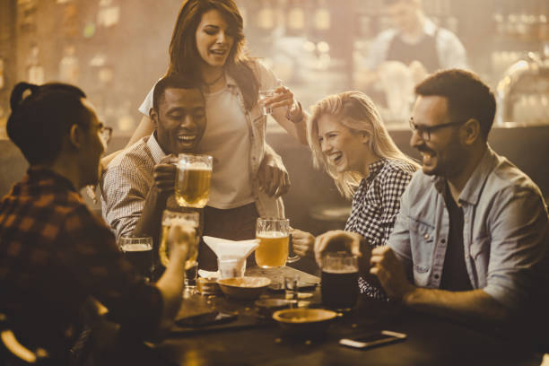 istock Group of cheerful friends having fun while talking during the night out in a pub. 1098289580