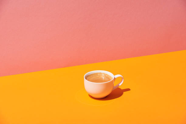 istock coffee cup on yellow surface and pink background 1098293036