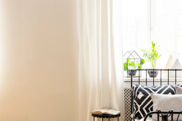 istock Table next to bed with patterned cushion in white bedroom interior with copy space. Real photo 1098293574