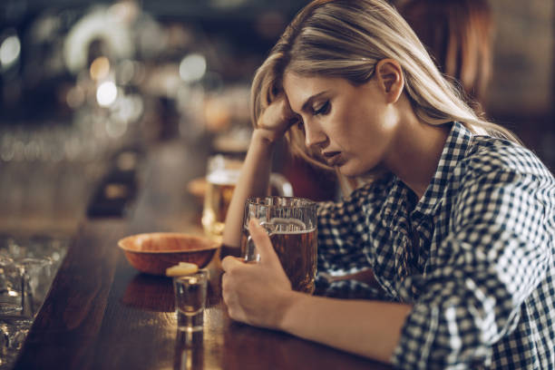 istock Lonely woman drinking beer at bar counter. 1098293780