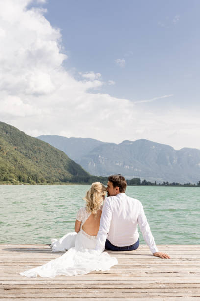 istock Beautyful wedding couple sitting on jetty 1098296350