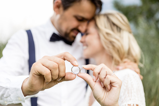 Couple holding wedding rings