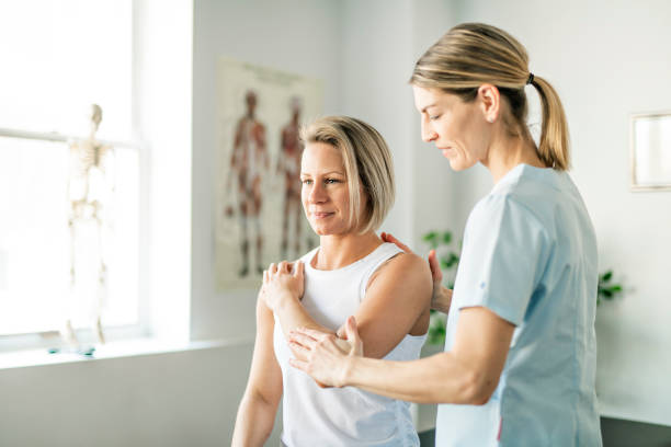 un trabajador de la fisioterapia de rehabilitación moderno con cliente mujer - pain shoulder physical injury sport fotografías e imágenes de stock