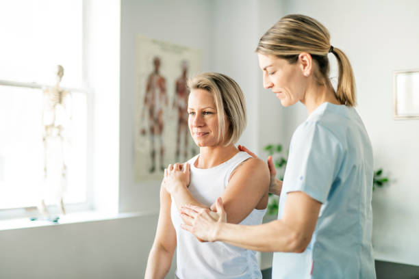 A Modern rehabilitation physiotherapy worker with woman client Modern rehabilitation physiotherapy worker with woman client alternative healthcare worker stock pictures, royalty-free photos & images