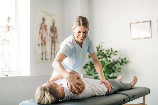 Modern rehabilitation physiotherapy worker with woman client
