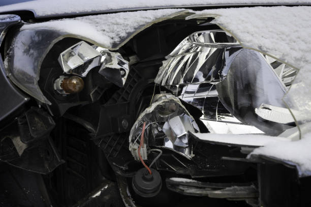 istock Broken car light accident. Close up of damaged headlight in a front car, winter. 1098299530