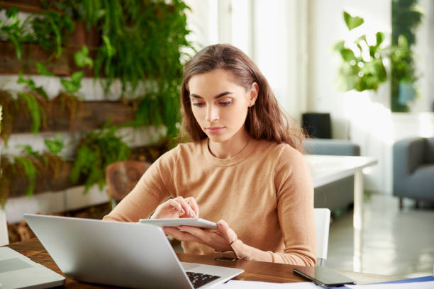 istock Young financial assistant businesswoman using digital tablet while working in the office 1098299802