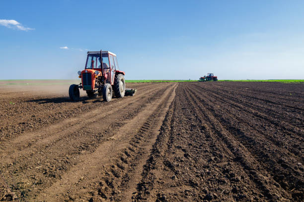 tractores en el campo agrícola la siembra en primavera - tillage fotografías e imágenes de stock