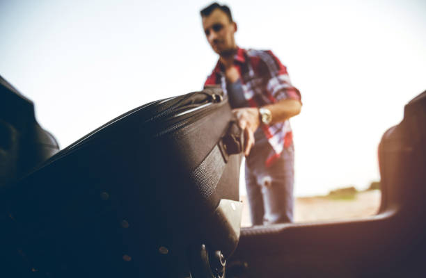 istock Putting suitcase in car trunk 1098303252