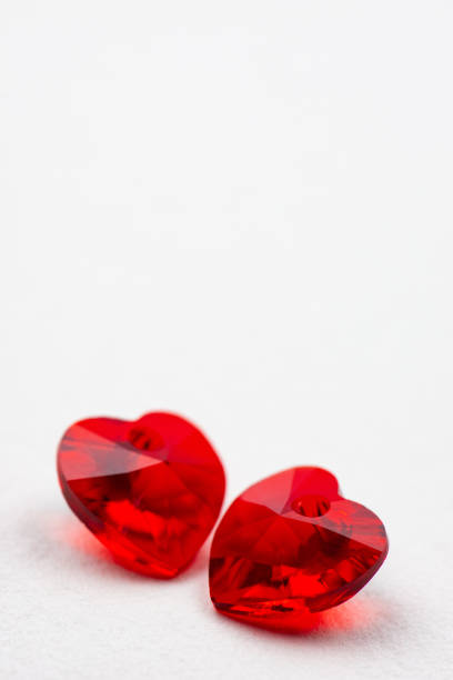 Red heart crystal on white paper, valentine's background