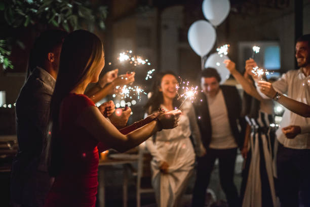 Bride and groom Just married couple showing up before their friends and running through the tunnel of sparklers wedding party stock pictures, royalty-free photos & images