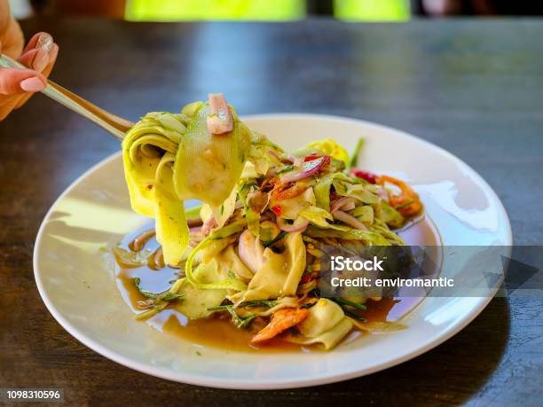 Thai Woman Using Wooden Chopsticks To Eat A Fresh Delicious Thai Spicy Bamboo And Prawn Thai Style Salad Thailand Stock Photo - Download Image Now