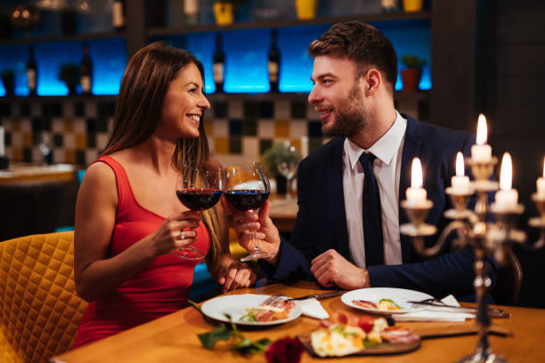 couple enjoying red wine on valentine's day - dating restaurant dinner couple imagens e fotografias de stock