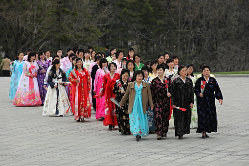 April 13, 2018. Pyongyang, North Korea.\nKim Il-Sung and Kim Jong-Il have special posters and monuments in different parts of the city. The most important of these monuments is the giant sculptures of North Korea's founding leader Kim Il-Sung and his son Kim Jong-Il. North Korean women in local suits are showing their respects to their leaders.