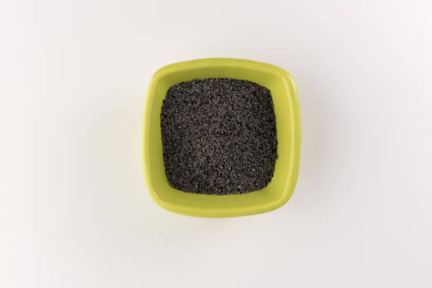 Poppy seeds in a ceramic plate isolated on white background. Selective focus