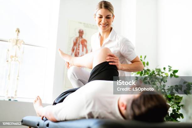 A Modern Rehabilitation Physiotherapy Woman Worker With Client Stock Photo - Download Image Now