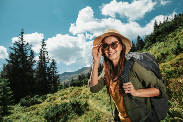 istock Young female traveler with backpack is posing in green meadow 1098315166