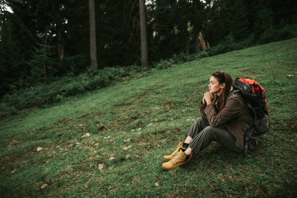 istock Beautiful girl with backpack sitting on green meadow 1098315248