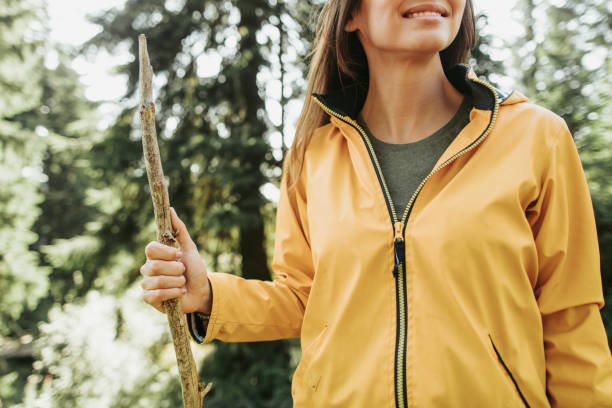 istock Smiling young lady with wooden stick standing in forest 1098316406