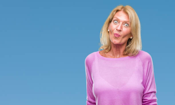 istock Middle age blonde woman over isolated background making fish face with lips, crazy and comical gesture. Funny expression. 1098318794