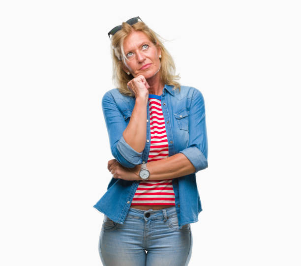 istock Middle age blonde woman over isolated background with hand on chin thinking about question, pensive expression. Smiling with thoughtful face. Doubt concept. 1098320704