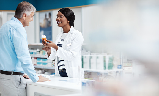 Shot of a female pharmacist assisting a customer in a drugstore