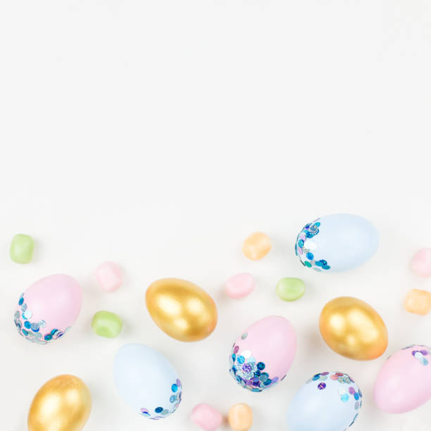 istock Festive Easter background with decorated eggs, flowers, candy and ribbons in pastel colors on white. Copy space 1098328582
