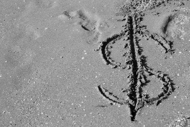 istock dollar symbol drawn on the sand 1098330286