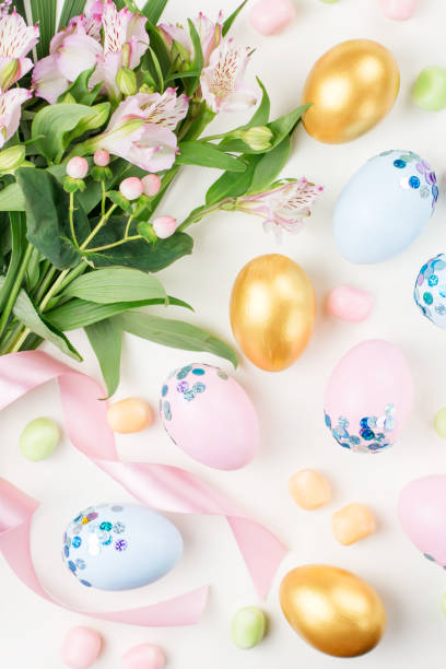 istock Festive Easter background with decorated eggs, flowers, candy and ribbons in pastel colors on white. Copy space 1098330806
