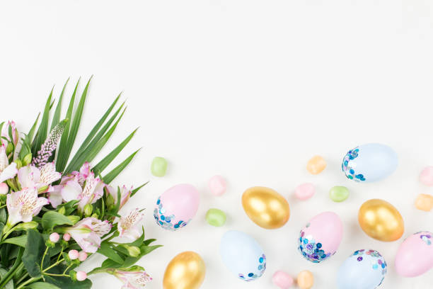 istock Festive Easter background with decorated eggs, flowers, candy and ribbons in pastel colors on white. Copy space 1098330810