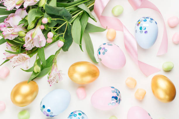 istock Festive Easter background with decorated eggs, flowers, candy and ribbons in pastel colors on white. Copy space 1098330826
