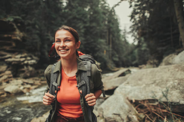 Waist up of a joyful woman traveling in the forest Cheerful attractive woman traveling near mountain river while spending weekend with pleasure timberland arizona stock pictures, royalty-free photos & images