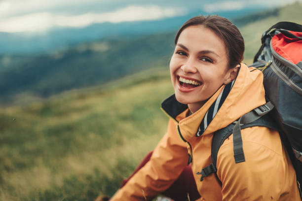 Cheerful smiling woman resting on the mountain slopes Delighted young woman resting on the slopes of the mountain while feeling happy timberland arizona stock pictures, royalty-free photos & images