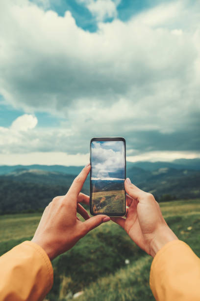 Close up of a smartphone with a photo of beautiful scenary Close up of a modern smartphone in hands of a female traveler making photos and resting in the mountains timberland arizona stock pictures, royalty-free photos & images