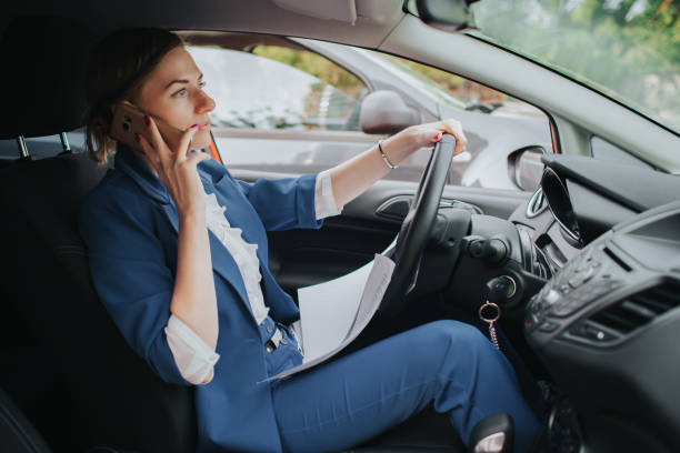 istock The driver going on the road, speaking on the phone, working with documents at the same time. Businesswoman doing multiple tasks. Multitasking business person. 1098333560
