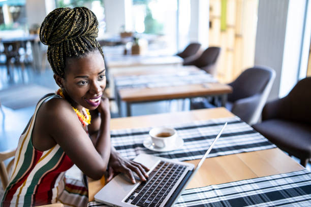 istock Elegant african woman using laptop in cafeteria 1098333740