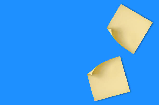 istock Two blank square yellow stickers with curved corner attached on blue table in office or fridge in home. Top view. Copy space for your text. Business or education concept 1098333996